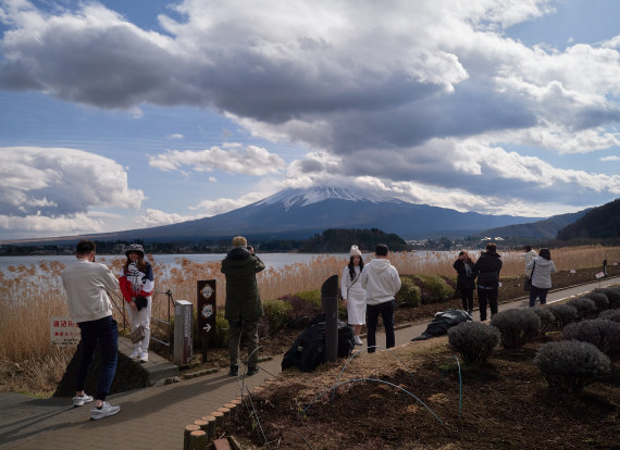 游客在日本山梨县河口湖畔欣赏富士山。新华社资料图